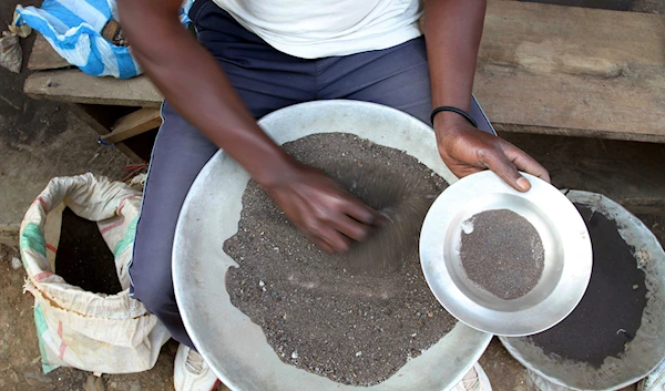 A Congolese miner sifts through ground rocks to separate out the cassiterite, the main ore that's processed into tin, in the town of Nyabibwe, eastern Congo, Aug. 16, 2012 (AP)