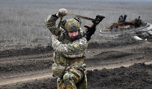 Illustrative: A Ukrainian soldier picks up a machine gun after a heavy fight on the front line in the village of Robotyne, Ukraine, Friday March 1, 2024. (AP)