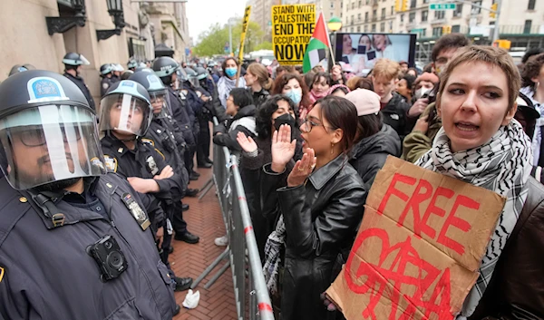 Police in Riot gear stand guard as demonstrators chant slogans outside the Columbia University campus, Thursday, April 18, 2024, in New York, US. (AP)