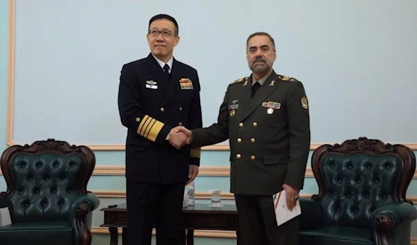 Iran's Defense Minister Brigadier General Mohammad Reza Ashtiani shakes hands with his Chinese counterpart Dong Jun during a meeting in Astana, Kazakhstan, on April 26, 2024.  (Iran's Defense Ministry)