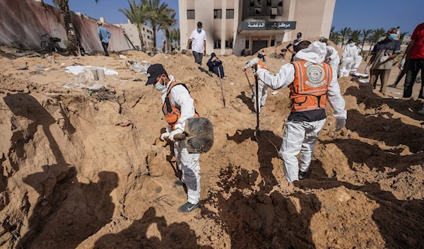 Palestinian health workers dig for bodies buried at Nasser Hospital compound in Khan Younis in the southern Gaza Strip on April 21, 2024 (AFP)