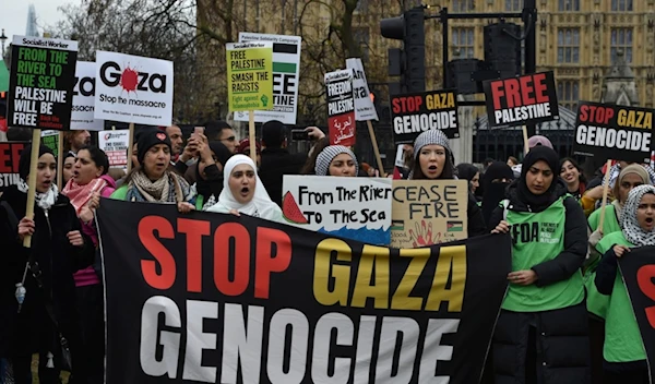 Pro-Palestine protesters hold banners and placards ahead of a march in support of the Palestinian people in Gaza, in London, Saturday, April 27, 2024 (AP Photo/Thomas Krych)