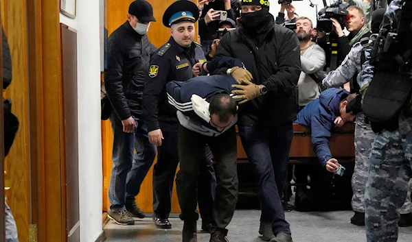 Saidakrami Murodali Rachabalizoda, a suspect in the Crocus City Hall shootings, is escorted by police and FSB officers in Basmanny District Court in Moscow, Russia, on March 24, 2024. (AP)