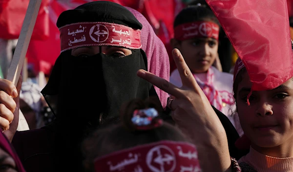 A woman from the Popular Front for the Liberation of Palestine (PFLP) waves her national and party's red flags in Gaza City, Thursday, Dec. 8, 2022. (AP)