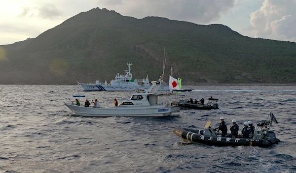 Japanese Coast Guard vessel and boats sail alongside a Japanese activists' fishing boat near a group of disputed islands called Diaoyu by China and Senkaku by Japan, early Sunday, Aug. 18, 2013. (AP)