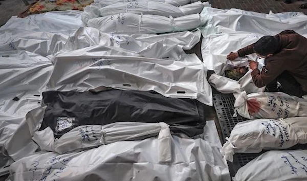 A man mourns over the shrouded bodies of his family members who were killed in an Israeli strike on a residential home in Rafah, January 2025. (AFP via Getty Images)