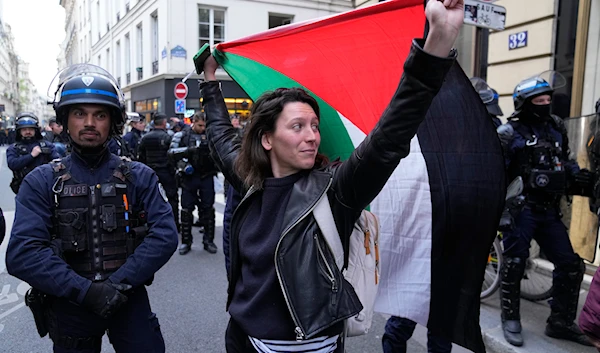 A woman holds a Palestine flag near Sciences-Po university in Paris on Friday, April 26, 2024.(AP)