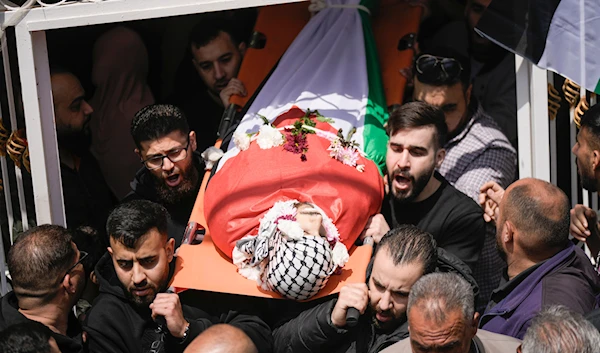 Palestinians carry the body of Omar Hamed during his funeral at the village of Beitin, near the West Bank city of Ramallah in the occupied West Bank, Sunday, April 14, 2024 (AP)