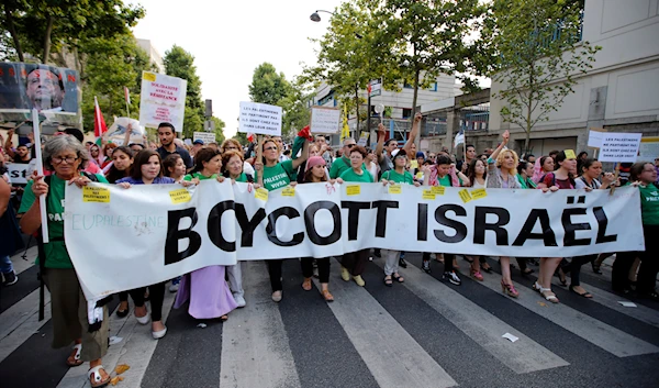 Pro-Palestinian demonstrators hold a banner and shout slogans, in Paris, France, Wednesday, July 23, 2014, during a demonstration to protest against the Israeli bombing of Gaza. (AP)