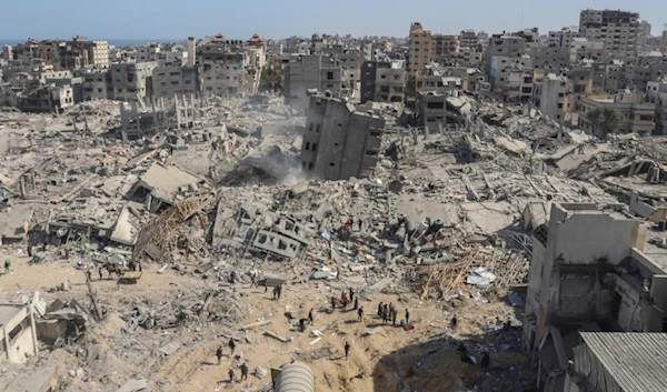 Palestinians walk through the destruction left by the Israeli air and ground offensive on the Gaza Strip near Shifa Hospital in Gaza City, Monday, April 1, 2024 (AP Photo/Mohammed Hajjar)