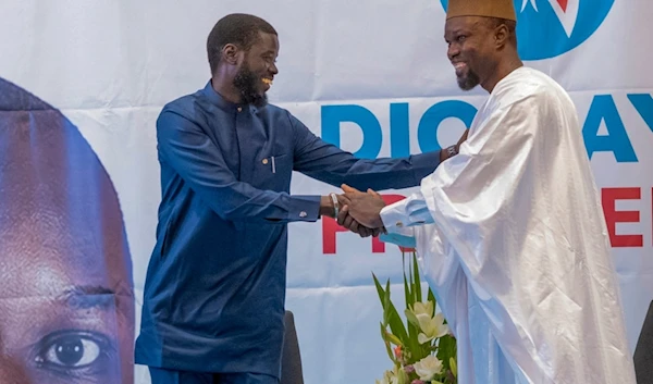 Senegal's top opposition leader Ousmane Sonko, right, and his key ally Bassirou Diomaye Faye address supporters in Dakar, Senegal, Friday March 15, 2024 (AP)