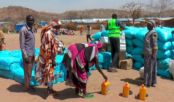 Sudanese refugees displaced by the conflict in Sudan gather to receive food staples from aid agencies at the Metche Camp in eastern Chad Tuesday, March 5, 2024 (AP)