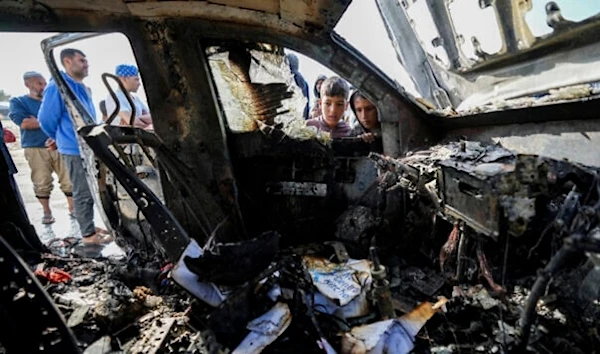 Palestinians inspect the site where World Central Kitchen workers were killed in Deir al-Balah, Gaza Strip, April 2, 2024. (AP)