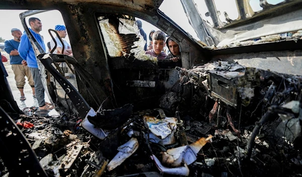 People inspect the site where World Central Kitchen workers were killed in Deir al-Balah, Gaza Strip, Tuesday, April 2, 2024 (AP)