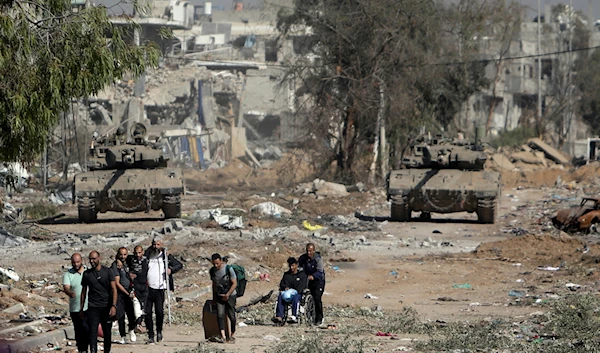 Palestinians flee from northern Gaza as Israeli tanks block the Salah al-Din road in the central Gaza Strip on Friday, Nov. 24, 2023. (AP)