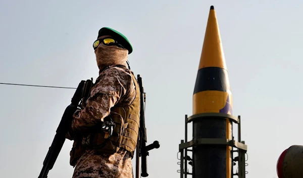 A IRGC member stands guard in front of an Iranian domestically built missile displayed during Basij paramilitary force rally in support of the Palestinians in Tehran, Iran, Nov. 24, 2023. (AP)