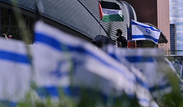 A man walks below flags flyng at a Pro-Palestinian encampment at MIT, Thursday, May 9, 2024, in Cambridge, Mass.(AP)