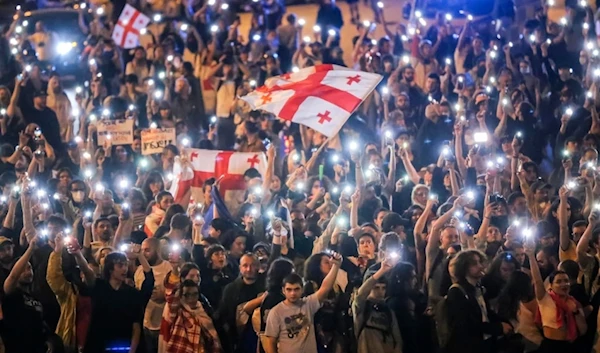 Demonstrators wave Georgian national flags during an opposition protest against foreign influence law in the center of Tbilisi, Georgia, on Thursday, May 2, 2024. (AP)