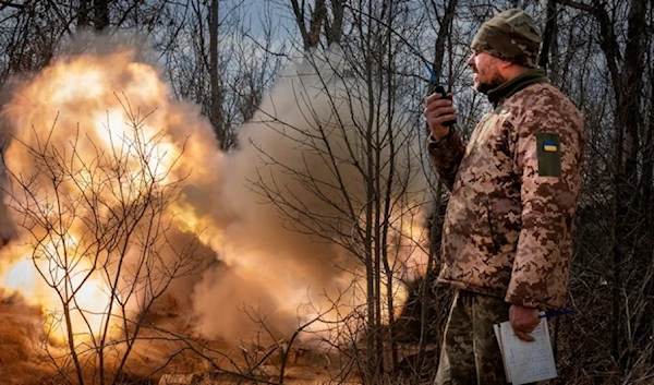 A Ukrainian officer observes the firing of a 152-mm Howitzer 2S3, towards Russian positions at the frontline, near Bakhmut, Donestk region, Ukraine, March 25, 2024 (AP)