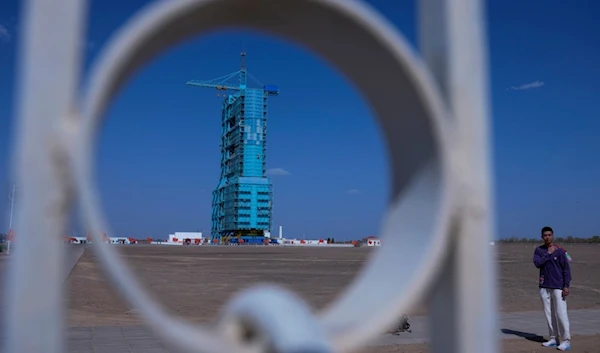 A soldier stands watch near the Shenzhou-18 spacecraft sitting atop a Long March rocket covered on a launch pad at the Jiuquan Satellite Launch Center in northwest China, Wednesday, April 24, 2024.