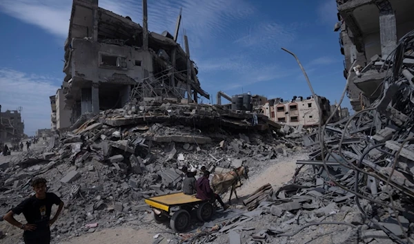 Palestinians walk through the destruction in the wake of an Israeli air and ground offensive in Khan Younis, southern Gaza Strip, Palestine, April 8, 2024. (AP)