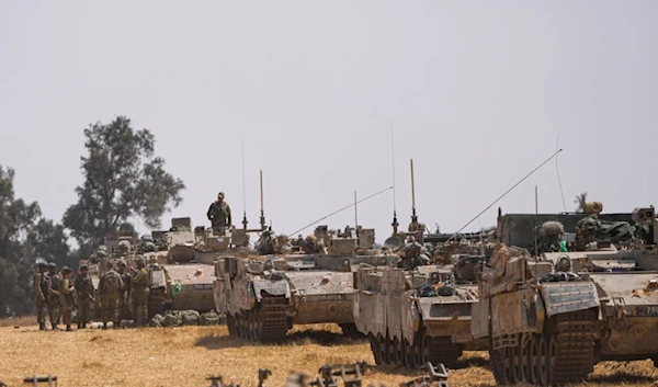 Israeli soldiers are seen at a staging ground near the separation line with Gaza, in southern occupied Palestine, Wednesday, May 1, 2024. (AP Photo/Ohad Zwigenberg)