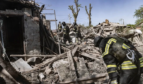 Firefighters inspect debris of a building hit by shelling in Kharkiv, Ukraine, Friday, May 3, 2024. (AP Photo/Yevhen Titov)