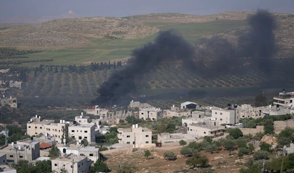 Smoke fills the sky after Israeli settlers set fire to the properties of Palestinian villagers in the West Bank village of al-Mughayyir, Saturday, April 13, 2024. (AP)