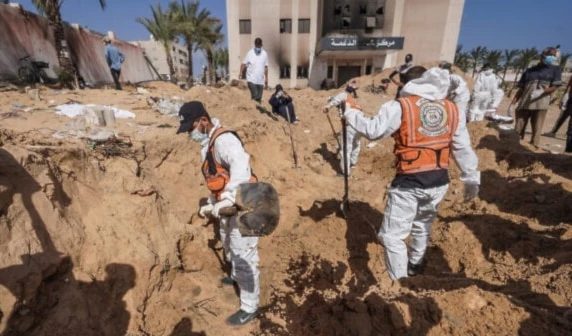 Palestinian health workers dig to recover bodies of martyrs killed and buried at mass graves at Nasser Hospital compound in Khan Younis in the southern Gaza Strip on April 21, 2024. (AFP)