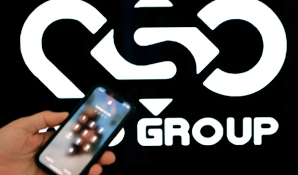 A person holding a phone showing the logo of Israeli spyware company NSO group. (AFP)