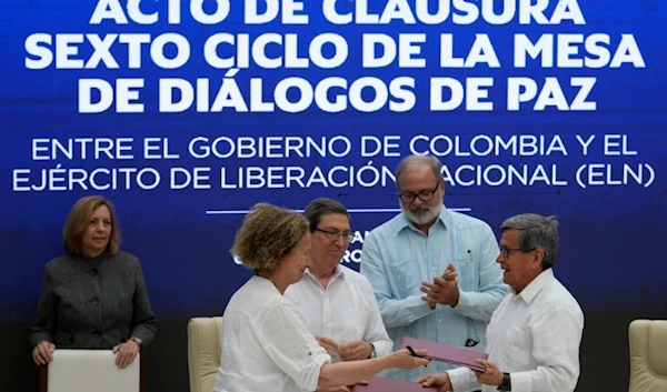 Colombian government rep. Vera Grabe and commander of the National Liberation Army (ELN) Pablo Beltran, exchange their signed ceasefire extension agreement in Havana, Cuba, Feb. 6, 2024. (AP)