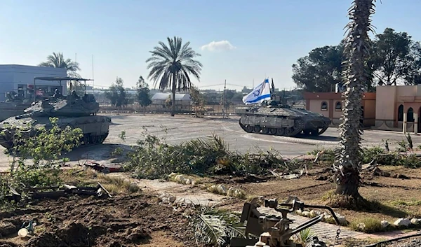 This photo shows a tank with an Israeli occupation flag on it entering the Gazan side of the Rafah border crossing in occupied Palestine, on Tuesday, May 7, 2024. (AP)