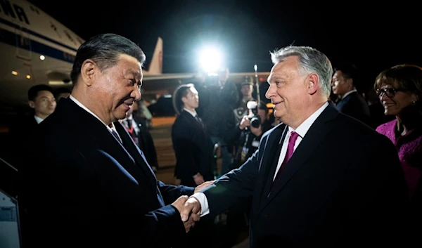 Chinese President Xi Jinping, left, shakes hands with Hungarian Prime Minister Viktor Orban as he arrives for a state visit at the Liszt Ferenc International Airport in Budapest, Hungary, Wednesday, May 8, 2024. (AP)