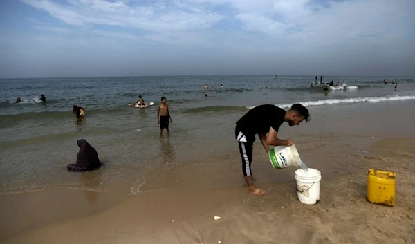 Palestinians resort to the seawater to bathe and clean their tools and clothes due to the continuing water shortage in the Gaza Strip, on the beach of Deir al-Balah, Central Gaza Strip, Sunday, Oct. 29, 2023. (AP)