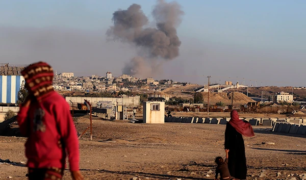 Smoke rises following an Israeli airstrike on buildings near the separating wall between Egypt and Rafah, southern Gaza Strip, occupied Palestine, May 7, 2024 (AP)