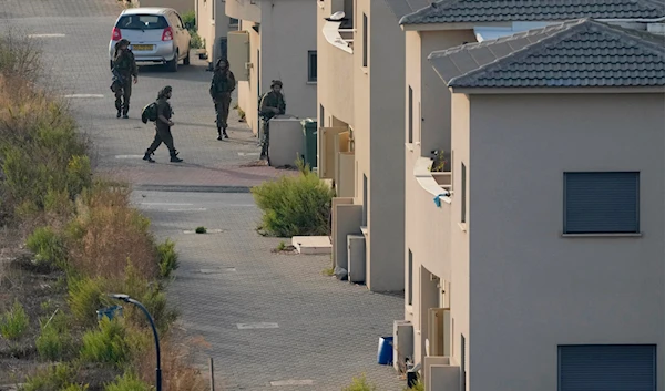 Israeli soldiers deploy between the houses in the Israeli town of Metula, as seen from the Lebanese side of the Lebanese-Palestinian border in the southern village of Kfar Kila, Lebanon, on October 8, 2023. (AP)