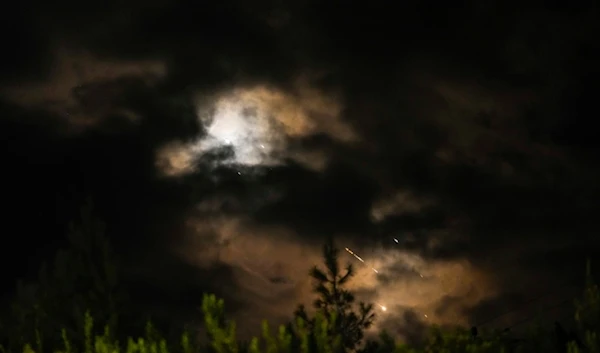 Projectiles fly through the sky in central occupied Palestine as a siren sounds a warning of incoming missiles fired from Iran towards the Israeli occupation, Tuesday, October 1, 2024 (AP)