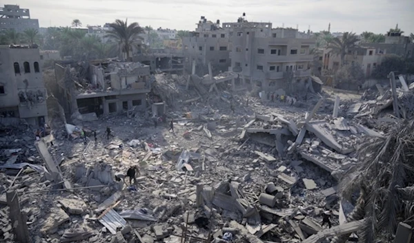 Palestinians look at destruction by the Israeli bombardment of the Gaza Strip in Deir al-Balah, occupied Palestine,Wednesday, November 22,2023. (AP)