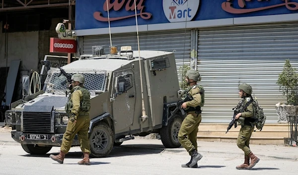 Israeli occupation officers walk back to their vehicles in the Palestinians al-Fara'a refugee camp in the occupied West Bank following an IOF military raid, on Monday, June 10, 2024. (AP)