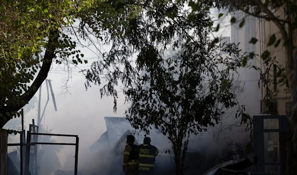 Firefighters work to extinguish a fire after a rocket, fired from Lebanon, hit the Israeli settlement of Kiryat Shmona, northern occupied Palestine, Wednesday, October 9, 2024 (AP)