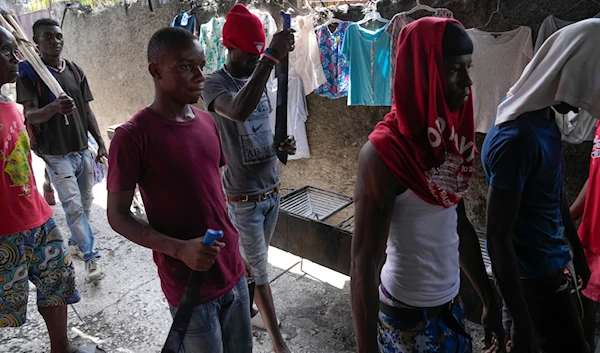 Men with machetes, part of "Bwa Kale," an initiative to resist gangs from getting control of their neighborhood, walk in the Delma district of Port-au-Prince, Haiti, on May 28, 2023. (AP)