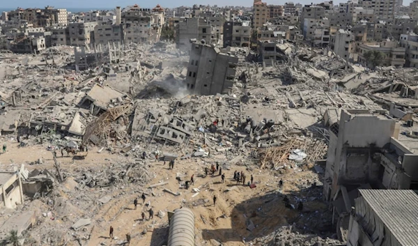 Palestinians walk through the destruction left by the Israeli air and ground offensive on the Gaza Strip near Shifa Hospital in Gaza City, Monday, April 1, 2024. (AP)