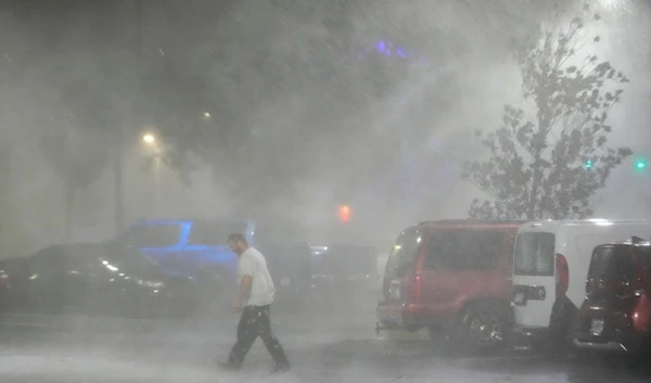 Max Watts, of Buford, Ga., walks in the parking lot to check on a trailer parked outside the hotel where he is riding out Hurricane Milton with coworkers, Wednesday, Oct. 9, 2024 (AP)