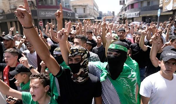 Palestinians wear Hamas scarves and headbands as they protest the assassination of Hamas top leader Ismail Haniyeh, in the West Bank city of Nablus, Wednesday, July 31, 2024 (AP)