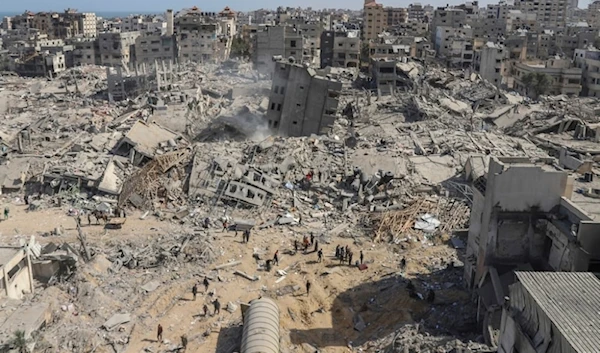 Palestinians walk through the destruction left by an Israeli air and ground offensive on the Gaza Strip near Shifa Hospital in Gaza City, Monday, April 1,2024. (AP)