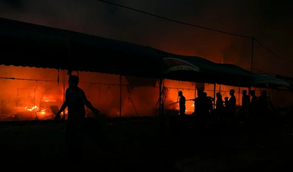 Palestinians try to extinguish a fire caused by an Israeli strike that hit a tent area in the courtyard of Al Aqsa Martyrs hospital in Deir al Balah, Gaza Strip, Monday, Oct. 14, 2024. (AP)