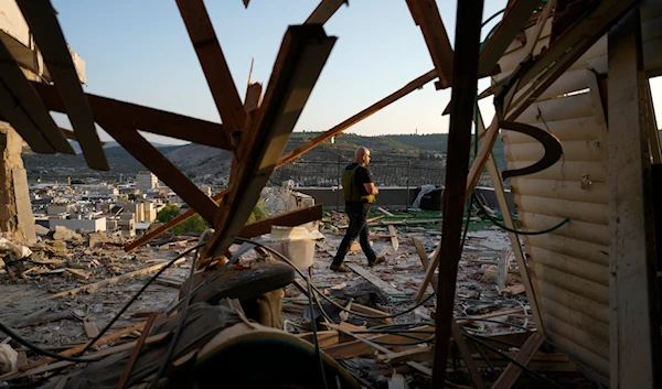 Israeli security forces survey damage to a home struck by a rocket fired from Lebanon in the town of Majd al-Krum, northern occupied Palestine, on October 16, 2024. (AP)