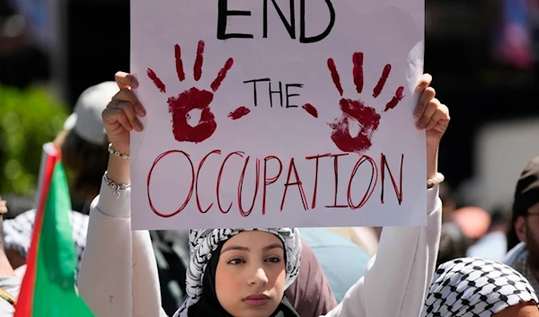 A woman holds a sign as people gather in central Sydney for a rally Sunday, Oct. 15, 2023, to support Palestinians in Gaza (AP)