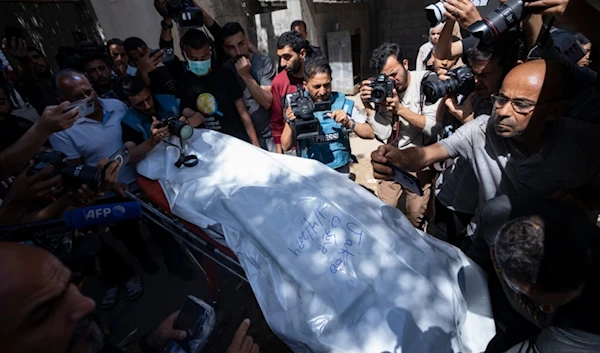 Members of the World Central Kitchen aid group, transports the body of one of the six foreign aid workers who were killed in an Israeli strike, at a hospital morgue in Rafah, Wednesday, April 3, 2024 (AP)