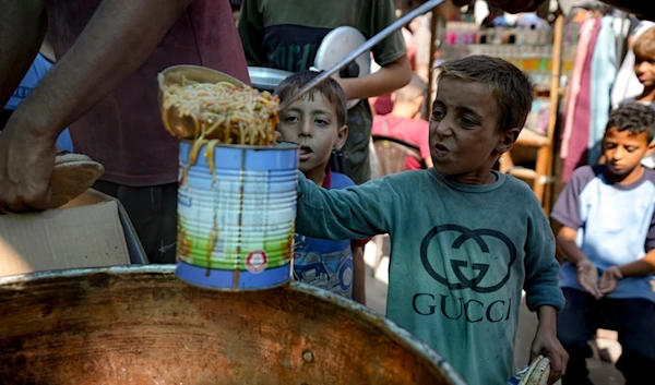 A displaced child lines up for food distribution in Deir al-Balah, Gaza Strip, Thursday, Oct. 17, 2024. (AP Photo/Abdel Kareem Hana)